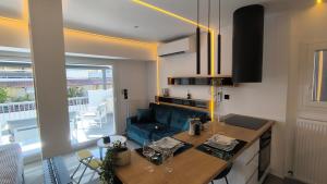 Una cocina con una mesa y un sofá en una habitación. en Larisa Absolute Suites, Sky View Smart Home, en Larisa