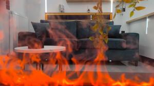 een woonkamer met een open haard voor een bank bij Larisa Absolute Suites, Sky View Smart Home in Larisa