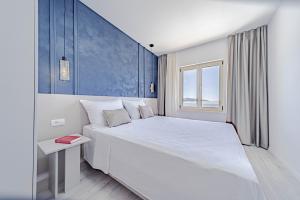 a bedroom with a large white bed and a window at Apartments by the sea Prizba, Korcula - 22068 in Blato