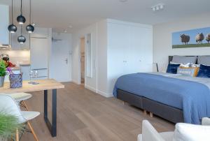 a bedroom with a bed and a table and chairs at Meeresbrise62 in Westerland