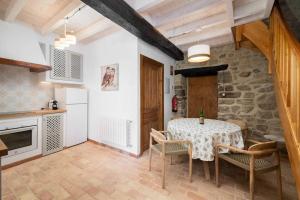 a kitchen with a table with chairs and a stone wall at La Casona de Obdulia II in Tresgrandas