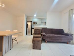 uma sala de estar com um sofá e uma mesa em Apartamento novo, vista mar, 150m da praia em Piçarras