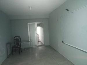 a white room with a glass table and a chair at Departamento con entrada independiente in Tehuacán +1 photo
