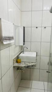 a white bathroom with a sink and towels at Apartamento em Itapuã in Vila Velha +8 photos