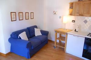カステッロ・テジーノにあるTesino Appartamentiのリビングルーム(青いソファ、テーブル付)