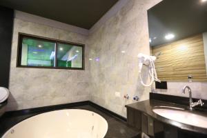 a bathroom with a tub and a sink and a window at Bellagio Motel in Foz do Iguaçu +52 photos