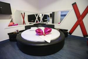 a room with a bed with a pink flower on it at Bellagio Motel in Foz do Iguaçu