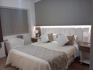 a bedroom with a large white bed with pillows at Hotel San Martín in Mendoza +30 photos