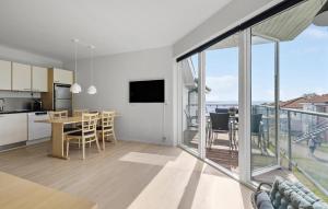 a kitchen and dining room with a view of a balcony at Gudhjem Søpark Lejl 28 in Gudhjem