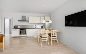a white kitchen with a table and chairs in it at Gudhjem Søpark Lejl 28 in Gudhjem