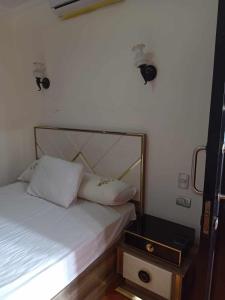 エル・アラメインにあるشقه فندقية بورت ماريناのベッドとナイトスタンドのある小さな寝室