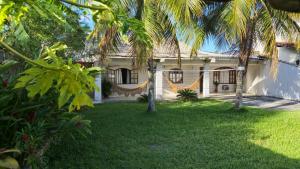 a white house with palm trees in the yard at Aldeia Maravista in Niterói