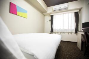 Postel nebo postele na pokoji v ubytování FLEXSTAY INN Kawasaki Kaizuka