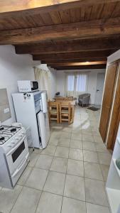 a large kitchen with white appliances and a table at Avistaje in Dina Huapi