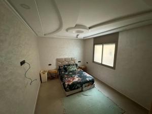 a bedroom with a bed and a window at Dahomey plage appartement Dahomey city in Bouznika