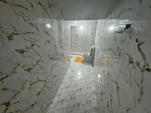 a white marble bathroom with a toilet in it at Dahomey plage appartement Dahomey city in Bouznika