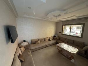 a living room with a couch and a table at Dahomey plage appartement Dahomey city in Bouznika