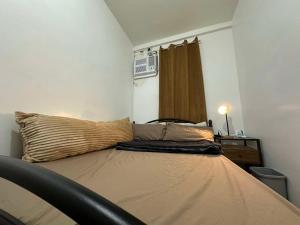 a bed in a small room with a bedskirtspectspectssenalsenalsenalsenal at Entire Townhouse - SANTO TOMAS BATANGAS in Santo Tomas