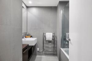 a bathroom with a sink and a shower at Sun filled & Spacious with Ocean Views & beach in Mount Maunganui +25 photos