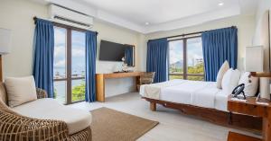 a hotel room with a bed and a tv and windows at Bluewater Maribago Beach Resort in Mactan