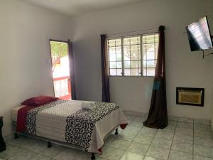 a bedroom with a bed and a window at Hotel La Villa in Retalhuleu