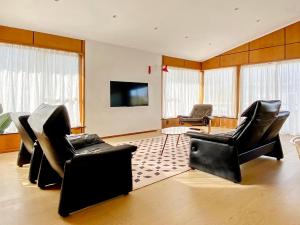 a living room with two chairs and a flat screen tv at Waterfront villa near IKEA and Sylvia Park in Auckland