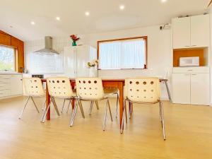 a kitchen with a dining room table and chairs at Waterfront villa near IKEA and Sylvia Park in Auckland
