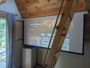 a projection screen in a room with a staircase at Tree Ring Cabin on 33 Acres in Powell River +13 photos