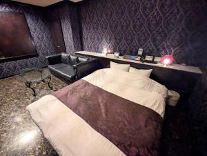 尼崎市卡奈特情趣酒店（仅限成人）的一间卧室，配有一张床、一把椅子和一台电视机