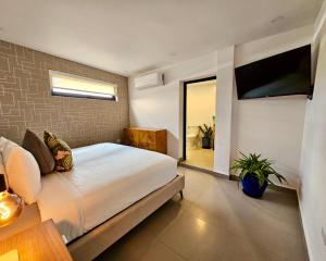 ein Schlafzimmer mit Bett und Flachbildfernseher in der Unterkunft La Calma Poshtel in San Juan