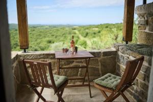 a table with a bottle of wine and two chairs on a balcony at Casa Minalu in Marušići