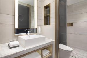 a bathroom with a white sink and a toilet at Fairfield by Marriott Beijing Olympic Sports Center in Beijing