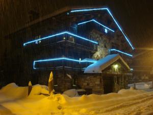 um edifício com luzes azuis sobre ele na neve em Chalet l'Avalin em Val dʼIsère