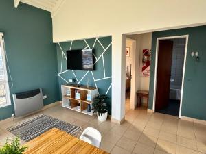 un salon avec une télévision sur un mur dans l'établissement TAAR AIKE II (Lugar de Hielo), à El Calafate