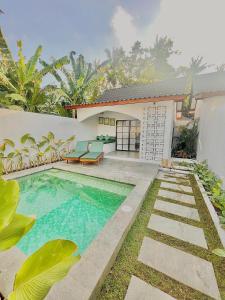 a swimming pool in the backyard of a house at Cozy Cottages Lombok in Senggigi