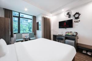 a hotel room with a bed and a desk and a tv at A25 Hotel - 109 Trúc Bạch in Hanoi