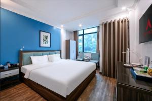 a bedroom with a large bed and a blue wall at A25 Hotel - 109 Trúc Bạch in Hanoi