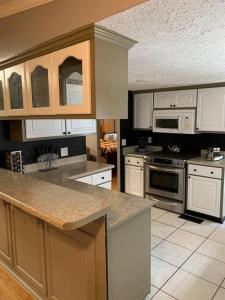 cocina grande con armarios y electrodomésticos blancos en Double Wide Getaway in PCB, en Panama City Beach 16 fotos más