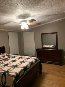 Un dormitorio con una cama, una cómoda y un espejo. en Double Wide Getaway in PCB, en Panama City Beach