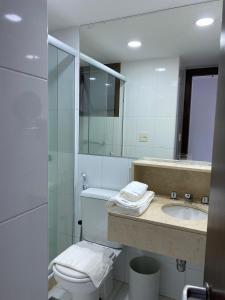 a bathroom with a toilet and a sink and a mirror at Botafogo Suites in Rio de Janeiro +27 photos