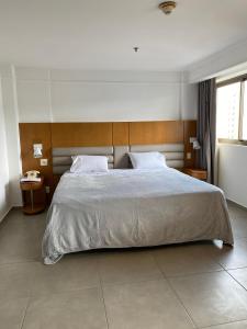 a bedroom with a large bed with a wooden headboard at Botafogo Suites in Rio de Janeiro
