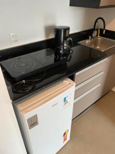 a kitchen with a stove top on top of a refrigerator at Botafogo Suites in Rio de Janeiro