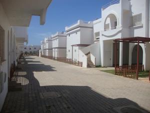 una calle vacía con una fila de edificios blancos en Maison Naila, en El Jadida