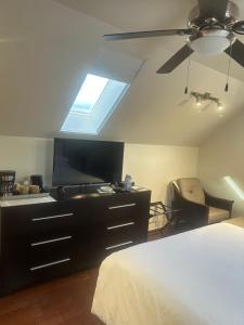 a bedroom with a bed and a flat screen tv at Upper Room in the Mission in Kelowna