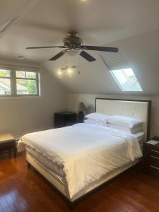 a bedroom with a bed with a ceiling fan at Upper Room in the Mission in Kelowna