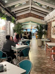 a group of people sitting at tables in a restaurant at Marietta - House of Social Travellers in Bogotá
