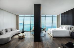 a living room with a bed and a couch at Awaken Da Nang Hotel in Danang