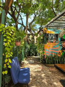 サンタ・クルスにあるCasaBus beautiful bus dept. 50m from beachのカラフルなバスの隣に置かれた青い椅子 +4枚の写真