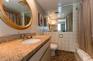 a bathroom with a sink and a mirror and a toilet at Rosellen Suites at Stanley Park in Vancouver