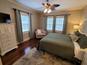 a bedroom with a bed and a dresser and a fan at Luxury Historic North Hills Home in Knoxville